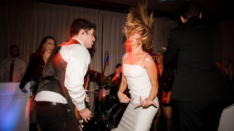Bride playing air guitar on stage