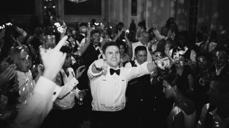 A lively wedding reception featuring guests dancing and celebrating under sparkling disco balls, showcasing the vibrant atmosphere created by a live wedding band. This energetic scene captures the joy and excitement of a memorable event, highlighting the importance of professional musicians to elevate the entertainment experience. Ben Mallare Events & Entertainment provides exceptional live wedding bands that keep the party going all night long.