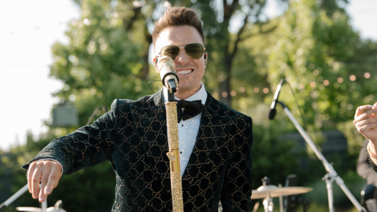 Hannah + Gary A lively performer in stylish attire stands confidently on stage, microphone in hand, ready to entertain guests at a Napa Valley wedding. This vibrant scene showcases the energy and professionalism of a live wedding band, perfect for creating unforgettable moments. Ben Mallare Events & Entertainment specializes in providing top-notch Napa Valley Live Wedding Bands Music Entertainment, ensuring every celebration is filled with exceptional music and joy.